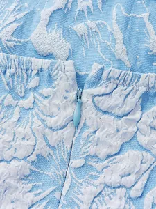 Detail view showing 3D floral jacquard texture and concealed zipper on blue dress