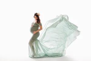 Detail of flowing green chiffon train on a maternity photography dress for photoshoot