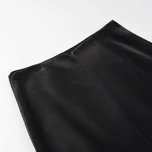 Detailed close-up showing the subtle glossy texture and stitching of an elegant black skirt