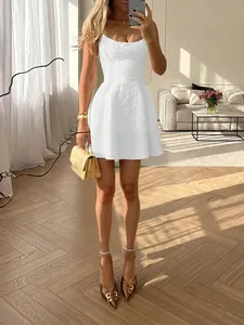 Detail of a white sleeveless floral textured mini dress with a chic square neck