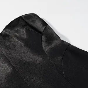 Detailed view of glossy black fabric texture on elegant satin blazer and skirt suit set