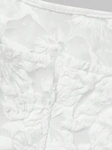 Detailed macro shot of back invisible zipper on white 3D floral textured lace dress