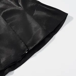 Close-up of black satin fabric showing the smooth texture and fine mermaid hem stitching detail.