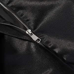 Close-up of high-quality metal zipper on elegant black satin blazer and skirt suit set