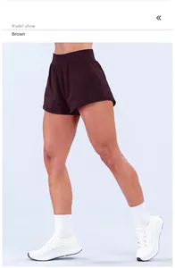 Vista dettagliata degli shorts da yoga a vita alta color caffè su una modella sportiva