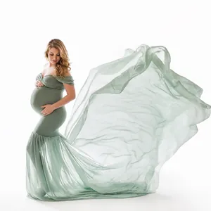 Elegant maternity photography dress in green with a long flowing chiffon train tail