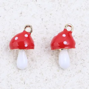 Detailed view of red and white enamel mushroom charms for DIY jewelry crafts