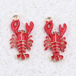 Detailed macro view of two red enamel lobster alloy pendants with gold-plated edges
