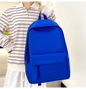 Minimalistischer, leuchtend blauer Rucksack, der in einem lässigen Innenraum gehalten wird