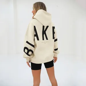 Oversized beige hooded sweatshirt featuring bold black BLAKE letter printing on back