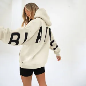 Detail shot of oversized cream hoodie with black printed text on back and sleeve