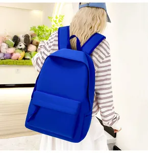 Model präsentiert einen leuchtend blauen Rucksack mit großem Fassungsvermögen