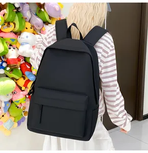 Ein minimalistischer schwarzer Studentenrucksack in einer Lifestyle-Umgebung vor Plüschtieren