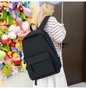 Minimalistischer schwarzer Rucksack für Studenten, getragen von einem Modell in Freizeitoptik