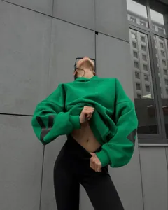 Detailed view of a thick green oversized hoodie with black sleeve print