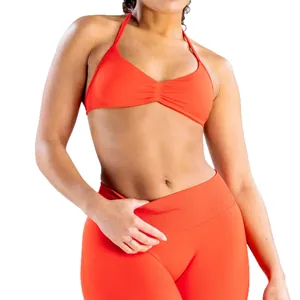 Vibrant orange halter yoga set with high-waisted leggings for fitness and gym wear.