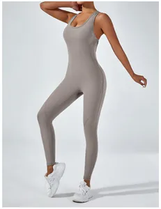 Full body view of a taupe high-elastic yoga jumpsuit for women in a bright studio