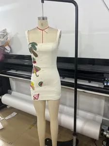 Detailed view of a white bodycon mini dress with colorful tropical beaded sequin patches