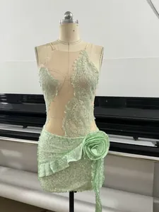 Detail view of mint green sequin dress featuring 3D flower and delicate lace embroidery