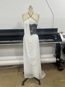White halter maxi dress with black lace detail and flowing drapes on mannequin