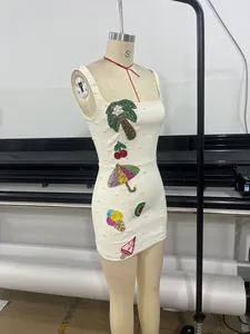 Detailed view of white bodycon dress with vibrant summer-themed beaded appliqués.