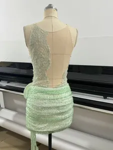 Close-up of a mint green sequin dress featuring intricate lace and a sheer back.