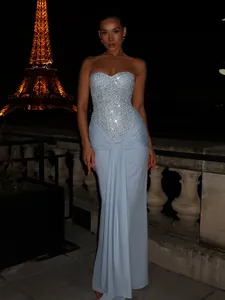Detailed view of a light blue sequined corset gown with draped pleated skirt texture
