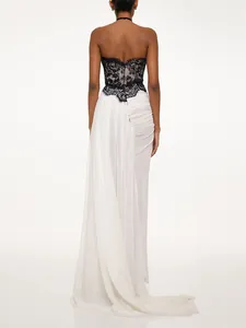 Back view of elegant black lace and white chiffon evening gown with a flowing train.