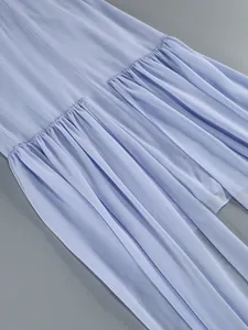 Detail of elegant light blue off-shoulder dress featuring pleated chiffon streamers.