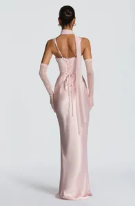 Back view of a pink satin evening gown with lace-up detail and matching sheer long gloves