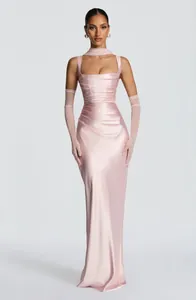 Detailed view of an elegant pink satin pleated evening gown with matching gloves
