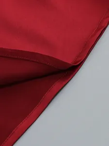 Close-up macro view showing the high-quality stitching on a dark red elegant evening dress