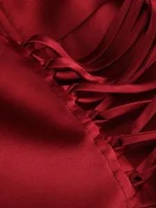 Close-up detail of wine red satin evening dress featuring elegant cross lacing