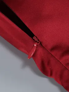 Close-up detail of hidden back zipper on elegant wine red evening dress, smooth fabric