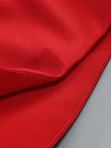 Close-up detail showing the fine stitching and premium red fabric texture of the dress