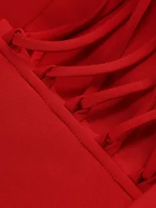 Close-up detail of red lace-up dress showing intricate strapping and fabric texture