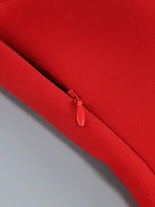 Close-up showing the concealed red zipper detail on a textured bodycon evening dress