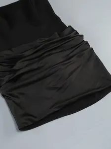 Detailed macro shot showcasing the elegant ruched satin texture on this black strapless dress
