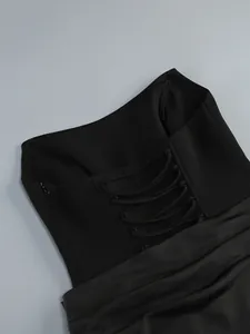 Detail of a black strapless evening dress featuring a lace-up back and corset structure