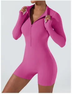 Detailed close-up of a pink long-sleeved one-piece workout bodysuit with front zipper