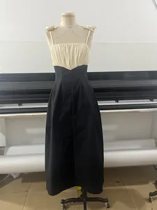 Elegant black and white contrast maxi dress with spaghetti straps and ruched bust design