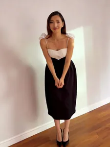 Elegant black and white contrast strap dress with slimming waist and bow details for vacation