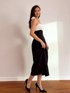 Full length view of black and white contrast midi dress with elegant ruffle straps