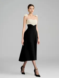 Elegant black and white contrast spaghetti strap midi dress with floral details.