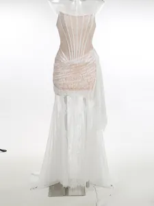 Front view detail of a white lace corset dress with sheer panels and floor-length skirt