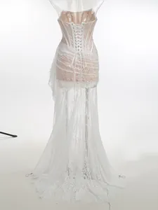 Detailed view of the corset lace-up back on a white floral lace evening gown.