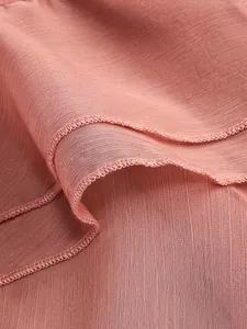 Detailed view of the sheer pleated fabric and overlock edge in elegant dusty rose