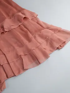 Detailed view of layered ruffles on a sheer dusty rose chiffon maxi dress fabric