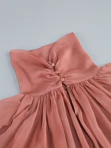 Close-up detail of the ruffled high neck and back covered buttons on a pink chiffon dress