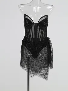 Détail d'une robe de soirée sexy en maille noire avec des strass et un ourlet irrégulier.
